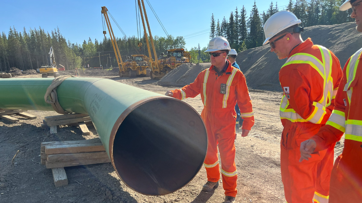 Workers next to a pipeline